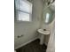 Powder room featuring pedestal sink, oval mirror, and window with blinds at 8232 Waxhaw Hwy, Waxhaw, NC 29173
