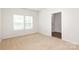 A sunlit bedroom with neutral carpeting, freshly painted walls, and a doorway to the hall at 8232 Waxhaw Hwy, Waxhaw, NC 29173