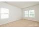 Bright, empty bedroom featuring carpeted floor and natural light from three windows at 8232 Waxhaw Hwy, Waxhaw, NC 29173