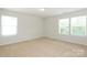 Bright, empty bedroom with carpeted floor and natural light from three windows at 8232 Waxhaw Hwy, Waxhaw, NC 29173