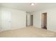 Bright, empty bedroom featuring carpeted floor, white walls, and three white doors at 8232 Waxhaw Hwy, Waxhaw, NC 29173