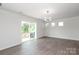 Bright living room featuring modern lighting, wood-look floors, and sliding glass door to outdoor balcony at 8232 Waxhaw Hwy, Waxhaw, NC 29173