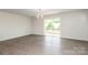 Spacious living area showcasing wood-look floors, contemporary light fixture, and sliding glass door to balcony at 8232 Waxhaw Hwy, Waxhaw, NC 29173