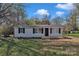 Charming one-story home featuring a front porch, black shutters, and a well-maintained lawn at 1034 Marietta St, Charlotte, NC 28214