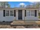 Straight on view of the home's entrance and porch, completed with fresh, natural-tone wood at 1034 Marietta St, Charlotte, NC 28214