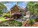Brick home exterior featuring a landscaped backyard with a stone patio and outdoor seating at 10602 Country Squire Ct, Matthews, NC 28105