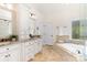 Elegant bathroom featuring a soaking tub, granite countertops and custom cabinetry at 10602 Country Squire Ct, Matthews, NC 28105