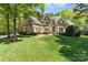 Charming brick home with a well-manicured lawn and lush landscaping, perfect for serene suburban living at 10602 Country Squire Ct, Matthews, NC 28105