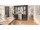 Dining area featuring custom built-in bar with granite counter, stainless refrigerator, and hardwood floors perfect for entertaining at 10602 Country Squire Ct, Matthews, NC 28105