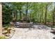 Outdoor living space featuring a stone fireplace, patio, and lush greenery in the background at 10602 Country Squire Ct, Matthews, NC 28105