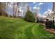 Large, green backyard with meticulously maintained lawn leading to a deck with a basketball court at 10928 Jardin Way, Charlotte, NC 28215