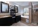 Luxurious bathroom with double vanity, soaking tub, and glass-enclosed shower with beautiful tile work at 10928 Jardin Way, Charlotte, NC 28215