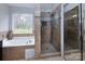 Bright bathroom featuring a soaking tub and a glass shower, designed for relaxation and convenience at 10928 Jardin Way, Charlotte, NC 28215