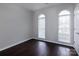 Cozy bedroom featuring dark wood floors, grey walls, and two arched windows with light streaming in at 10928 Jardin Way, Charlotte, NC 28215