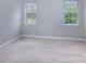 Neutral bedroom featuring carpet floors, trim, and two windows providing natural light at 10928 Jardin Way, Charlotte, NC 28215