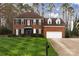 Traditional brick home with a well-maintained lawn and two-car garage with an inviting covered front entrance at 10928 Jardin Way, Charlotte, NC 28215