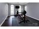 Home gym featuring weightlifting equipment, dark wood flooring, and ample natural light from the windows at 10928 Jardin Way, Charlotte, NC 28215
