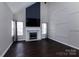 Open living room with fireplace, dark wood floors, high ceilings, and lots of natural light at 10928 Jardin Way, Charlotte, NC 28215