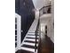 An elegantly designed staircase with dark wood floors and white risers and dark trim leading to upper level at 10928 Jardin Way, Charlotte, NC 28215