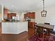 Open kitchen featuring stainless steel appliances, granite countertops, and dark wood cabinetry and flooring at 11621 Red Knoll Ln, Pineville, NC 28134