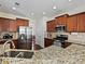 Kitchen featuring stainless steel appliances, granite countertops, wood cabinets, and a double sink at 11621 Red Knoll Ln, Pineville, NC 28134