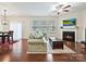 Bright living room with a fireplace, hardwood floors, neutral walls, and a ceiling fan at 11621 Red Knoll Ln, Pineville, NC 28134