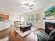Open-concept living room with hardwood floors, fireplace, ceiling fan, and access to dining area at 11621 Red Knoll Ln, Pineville, NC 28134