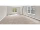 Large, carpeted bedroom with bright, natural light pouring through the windows at 119 Tilton Dr, Mooresville, NC 28115