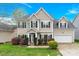 Charming two-story home boasts manicured lawn and lush landscaping at 119 Tilton Dr, Mooresville, NC 28115