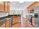 Well-lit kitchen with granite counters, wood cabinets, and stainless steel appliances at 119 Tilton Dr, Mooresville, NC 28115