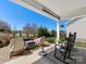 Covered back porch with outdoor seating and pleasant landscaping at 121 Hanks Bluff Dr, Mooresville, NC 28117