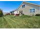 Scenic backyard view with green grass, flowers, patio, and cozy outdoor seating area at 121 Hanks Bluff Dr, Mooresville, NC 28117