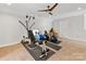 Finished basement area with fitness equipment, neutral carpet, a ceiling fan, and an accent chair at 121 Hanks Bluff Dr, Mooresville, NC 28117