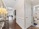Hallway with hardwood floors leading to other rooms and a bathroom with a blue rug at 121 Hanks Bluff Dr, Mooresville, NC 28117