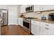 Well-lit kitchen with stainless steel appliances, ample white cabinetry, and hardwood floors at 121 Hanks Bluff Dr, Mooresville, NC 28117