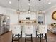 Stylish kitchen island with seating, modern lighting, and stainless steel appliances at 121 Hanks Bluff Dr, Mooresville, NC 28117