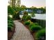 A winding landscaped path leading to a serene lake is flanked by lush greenery at 121 Hanks Bluff Dr, Mooresville, NC 28117