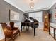 Elegant living room with a grand piano, leather chair, and classic decor at 121 Hanks Bluff Dr, Mooresville, NC 28117