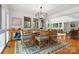 Open dining area with views into living room; features modern chandelier, seating for six, and wood floors at 121 Rhinehill Dr, Mooresville, NC 28117