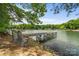 Lake view featuring a weathered wooden dock and comfortable seating to relax and enjoy waterfront living at 121 Rhinehill Dr, Mooresville, NC 28117