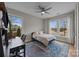 Bright bedroom featuring a ceiling fan, hardwood floors, and two large windows that provide natural light at 12619 Old Westbury Dr, Cornelius, NC 28031