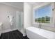 Bright bathroom features a soaking tub, glass enclosed shower and black tile flooring at 1300 Aragon Beach Rd, Rock Hill, SC 29732