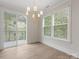 Bright dining room with wood floors, a chandelier, large windows, and access to an outdoor balcony at 1413 Kenilworth Ave, Charlotte, NC 28203