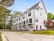 Modern white townhomes featuring balconies, garage doors, and well-maintained landscaping, perfect for contemporary living at 1413 Kenilworth Ave, Charlotte, NC 28203