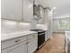 Elegant kitchen with white cabinets, granite countertops, modern appliances, and wood floors at 1413 Kenilworth Ave, Charlotte, NC 28203