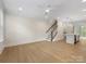Open living space featuring hardwood floors, a modern ceiling fan, and access to the staircase at 1413 Kenilworth Ave, Charlotte, NC 28203