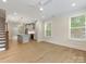 Open-concept living area with hardwood floors, kitchen views, and natural light from windows at 1413 Kenilworth Ave, Charlotte, NC 28203