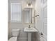 Stylish powder room with a pedestal sink, gold fixtures, and a modern mirror at 1413 Kenilworth Ave, Charlotte, NC 28203