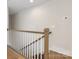 Upper level staircase with stained wood handrail and white risers, offering access to the upper floors of this home at 1413 Kenilworth Ave, Charlotte, NC 28203