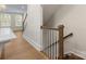 Hardwood staircase with white risers and wood railing adjacent to kitchen and hardwood floor at 1413 Kenilworth Ave, Charlotte, NC 28203
